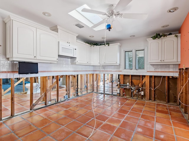 kitchen with tasteful backsplash, ceiling fan, and white cabinets