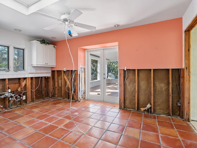 interior space with white cabinetry, french doors, ceiling fan, and light tile patterned floors