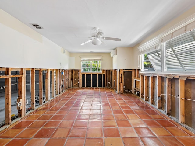 spare room with a wall mounted air conditioner, plenty of natural light, ceiling fan, and wooden walls