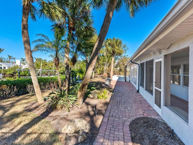 view of yard with a sunroom and a patio