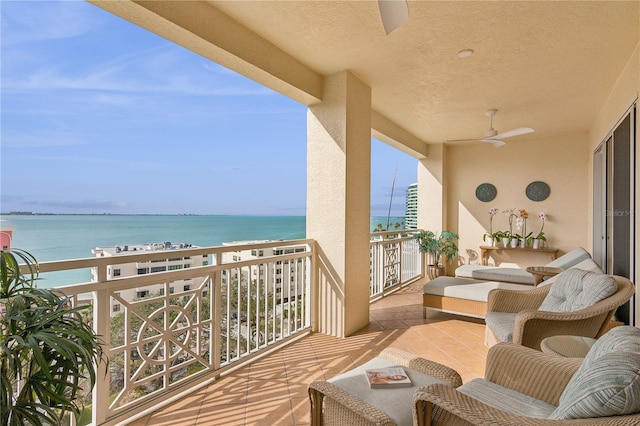 balcony with ceiling fan and a water view