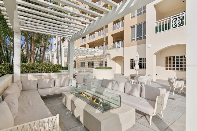 view of patio featuring a pergola and an outdoor living space with a fire pit