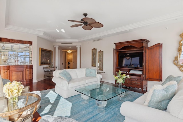 living room featuring ceiling fan, crown molding, ornate columns, and dark wood-type flooring