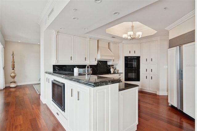 kitchen with white cabinets, built in appliances, dark hardwood / wood-style floors, and custom exhaust hood