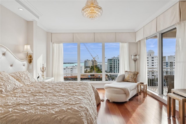 bedroom with access to exterior, hardwood / wood-style flooring, multiple windows, and ornamental molding