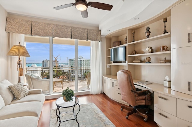 office featuring ceiling fan, built in desk, and light hardwood / wood-style floors