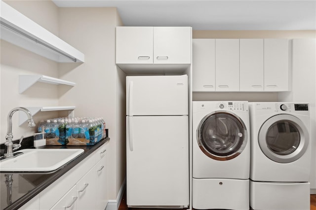 laundry room with cabinets, separate washer and dryer, and sink