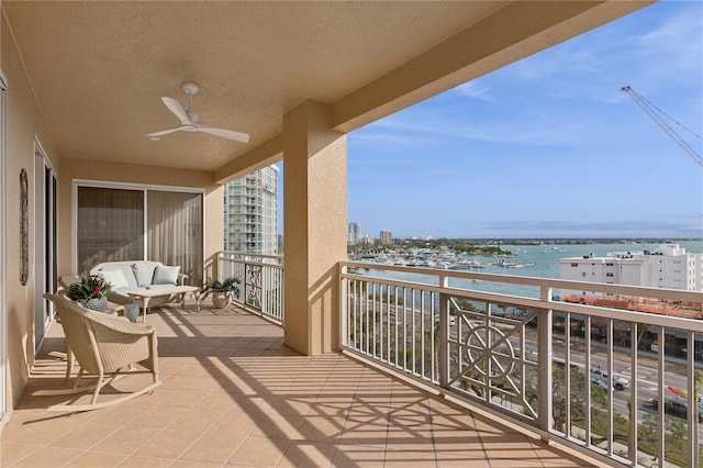 balcony with a water view and ceiling fan