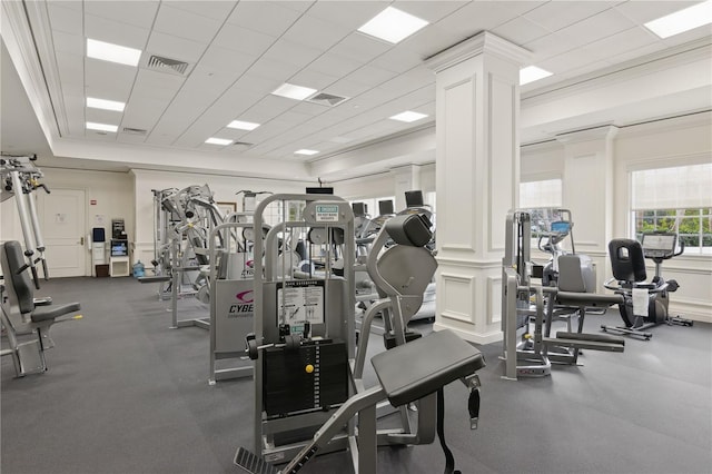 exercise room with ornate columns, a drop ceiling, and ornamental molding