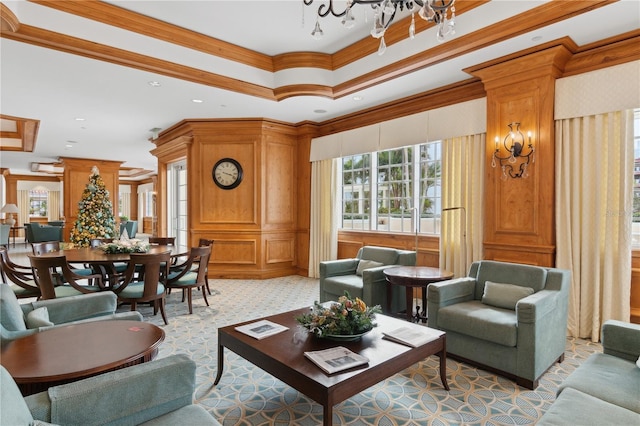 living room featuring a notable chandelier, a raised ceiling, and crown molding