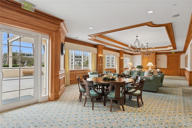 dining area featuring a raised ceiling, ornamental molding, and a notable chandelier