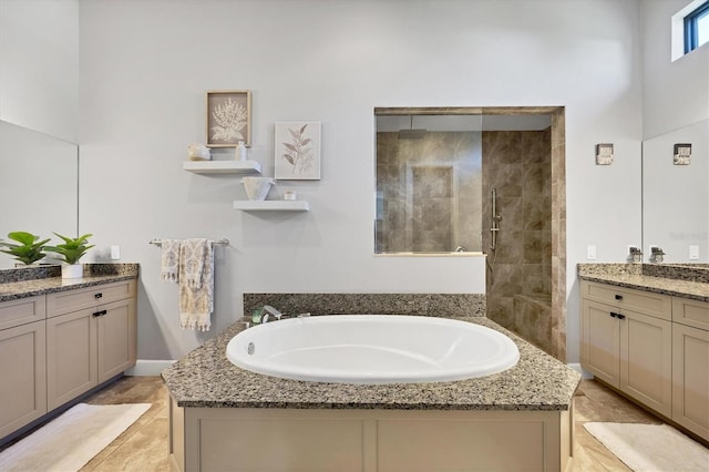 bathroom with vanity, tile patterned flooring, and plus walk in shower