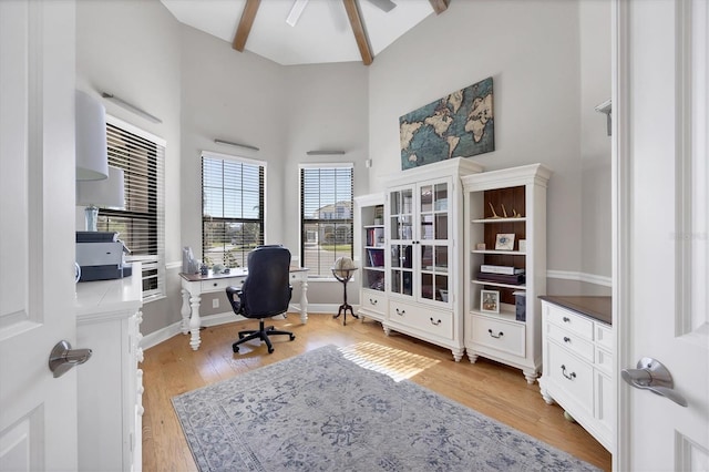 office featuring beam ceiling, ceiling fan, light hardwood / wood-style flooring, and high vaulted ceiling