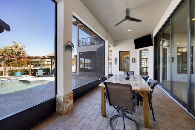 sunroom / solarium featuring ceiling fan