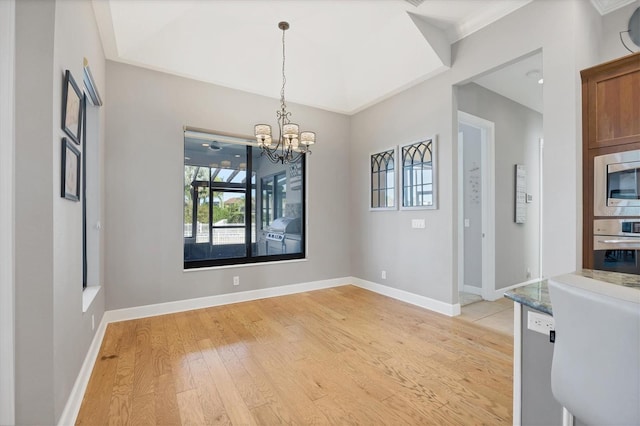 unfurnished dining area featuring light hardwood / wood-style floors, ornamental molding, and a chandelier