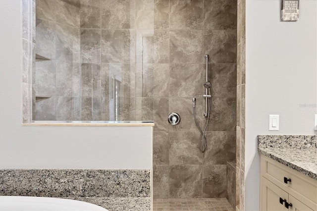 bathroom with tiled shower and vanity