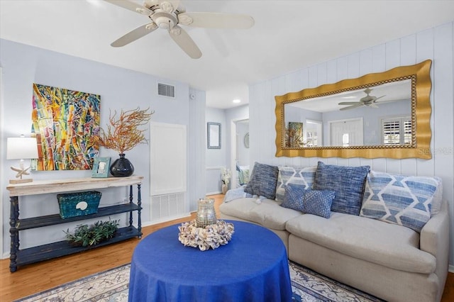 living room featuring wood-type flooring and ceiling fan