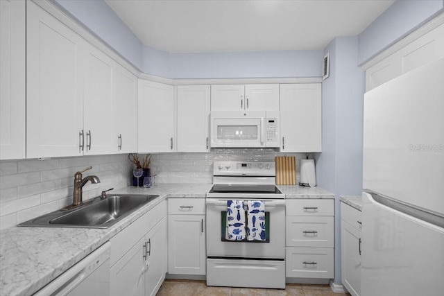 kitchen featuring white appliances, white cabinets, tasteful backsplash, and sink