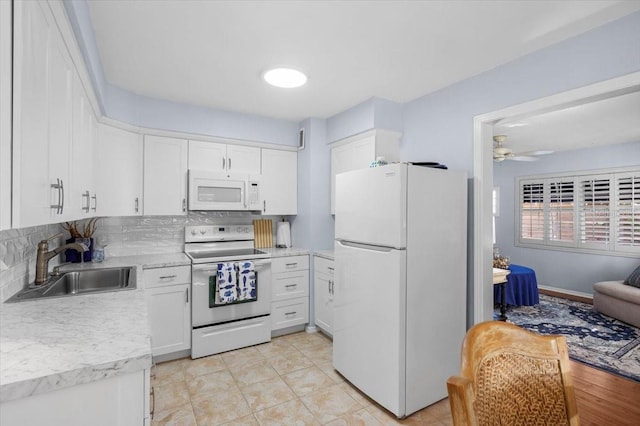 kitchen with white appliances, ceiling fan, sink, white cabinetry, and tasteful backsplash