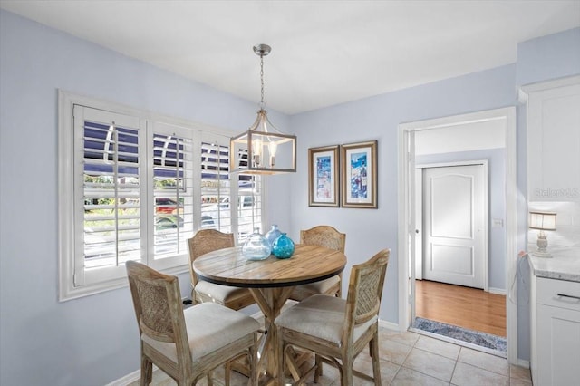 dining area with light tile patterned floors and a notable chandelier