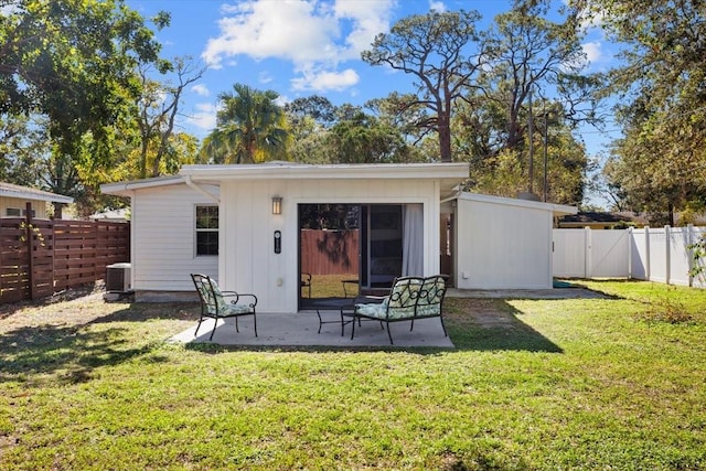 back of house with a yard, central air condition unit, and a patio area