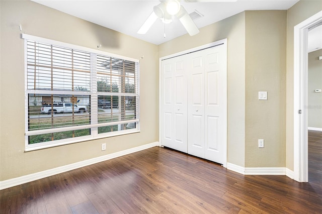 unfurnished bedroom featuring a closet, dark hardwood / wood-style floors, and ceiling fan