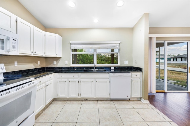 kitchen featuring white cabinets, a healthy amount of sunlight, white appliances, and sink