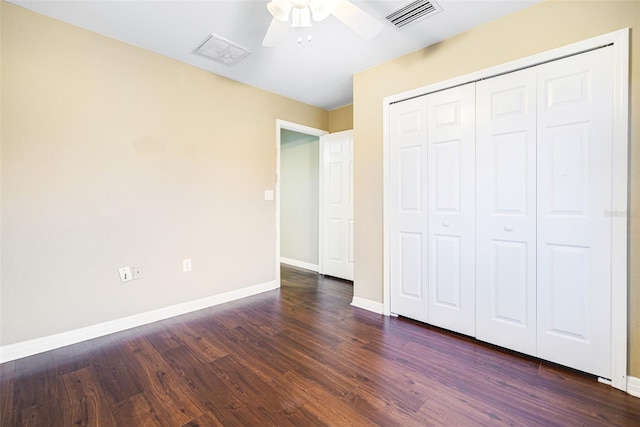 unfurnished bedroom with dark hardwood / wood-style flooring, a closet, and ceiling fan