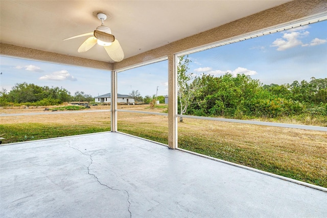 unfurnished sunroom featuring ceiling fan