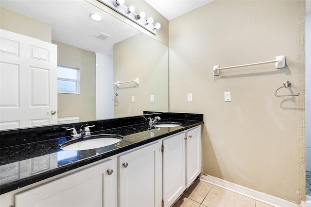 bathroom with tile patterned flooring, vanity, and toilet