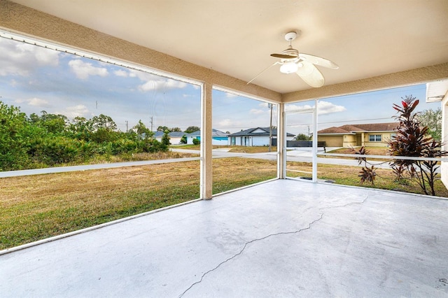 unfurnished sunroom featuring ceiling fan