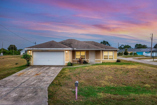 single story home featuring a garage and a lawn