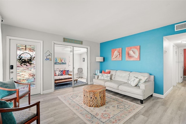 living room with light wood-type flooring and ceiling fan