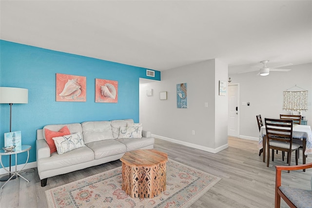 living room featuring ceiling fan and light wood-type flooring