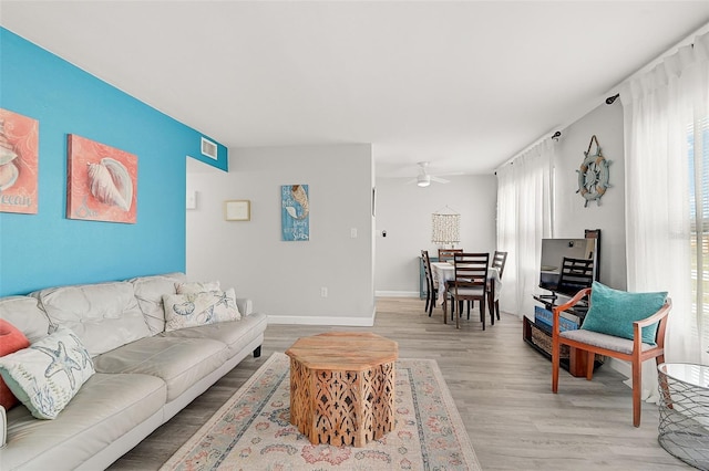 living room with ceiling fan and light hardwood / wood-style flooring