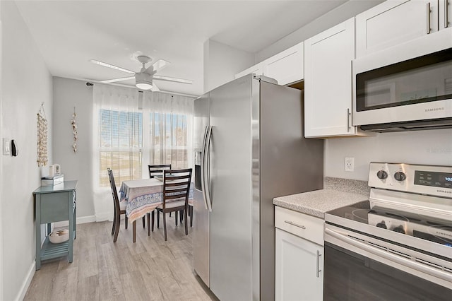 kitchen featuring ceiling fan, white cabinetry, stainless steel appliances, and light wood-type flooring