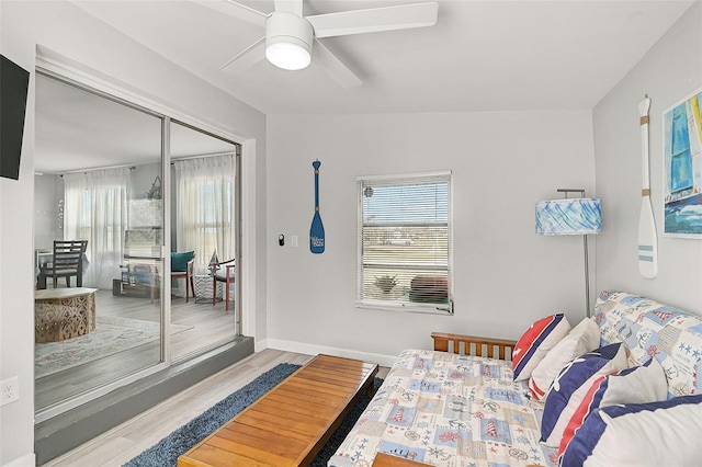 bedroom with ceiling fan, a closet, multiple windows, and light hardwood / wood-style floors