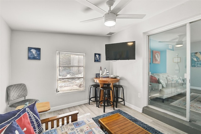 sitting room with ceiling fan and light wood-type flooring