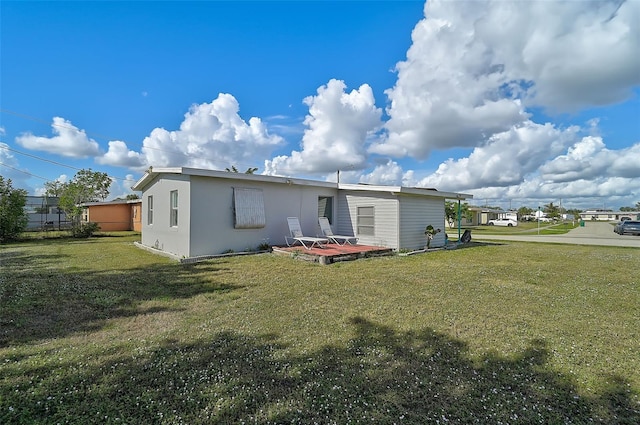 back of house featuring a deck and a yard