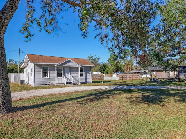 view of front of home featuring cooling unit and a front lawn