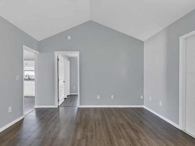 empty room with sink, lofted ceiling, and dark wood-type flooring