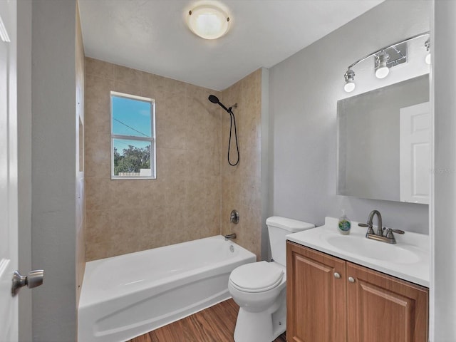 full bathroom with hardwood / wood-style floors, vanity, toilet, and tiled shower / bath