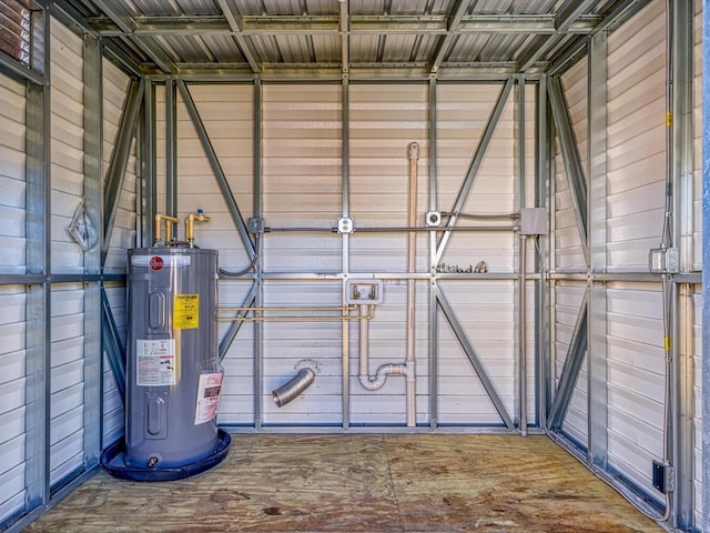 garage featuring electric water heater and wooden walls