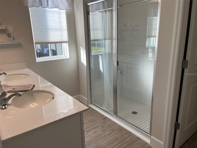 bathroom with vanity, a shower with shower door, and hardwood / wood-style flooring