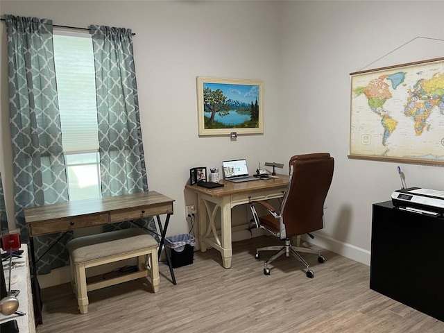 home office with light hardwood / wood-style flooring