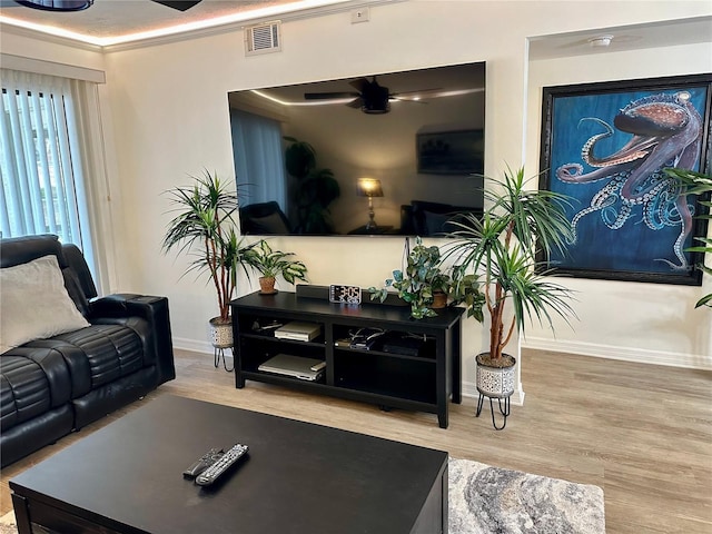 living room featuring ceiling fan, light hardwood / wood-style floors, and ornamental molding