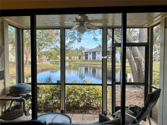 sunroom / solarium with a wealth of natural light, a water view, and ceiling fan