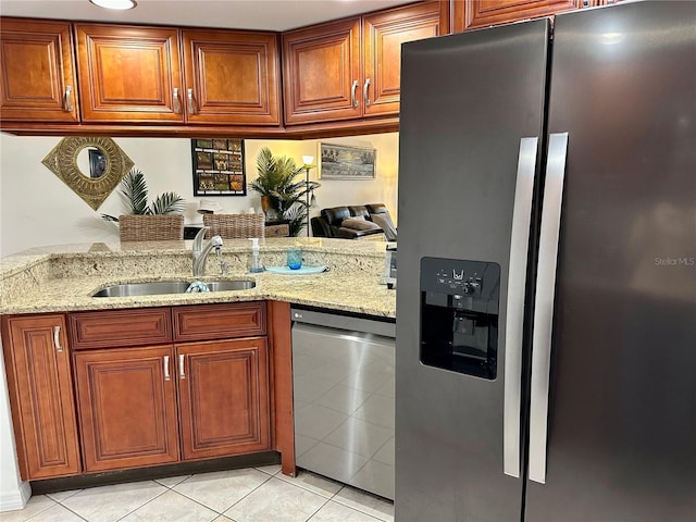 kitchen featuring sink, light tile patterned floors, light stone counters, kitchen peninsula, and stainless steel appliances