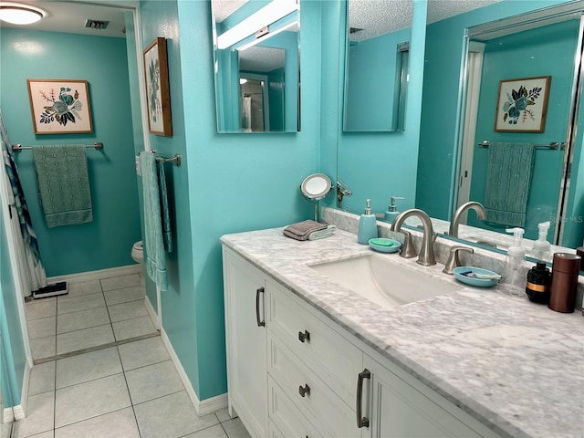 bathroom with tile patterned flooring, vanity, a textured ceiling, and toilet