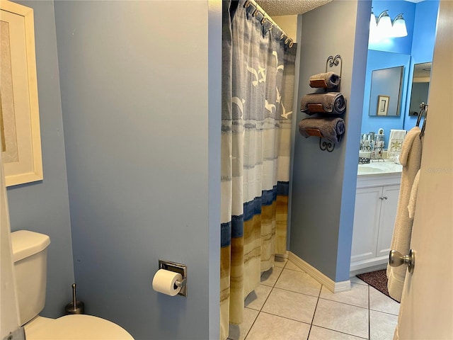 bathroom with tile patterned floors, vanity, walk in shower, and toilet